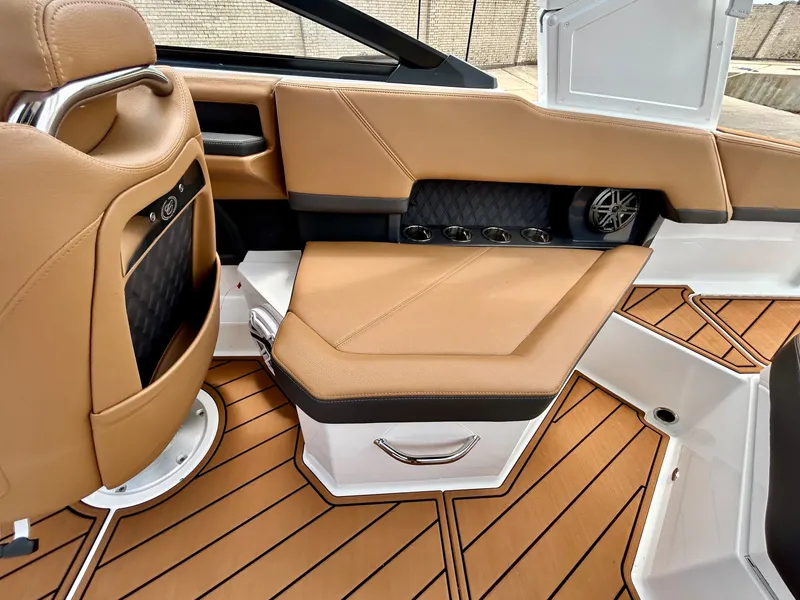 Slide: The Image of The image shows the interior of a 2027 Cobalt R4 boat with sleek brown seating and wood flooring. - 43