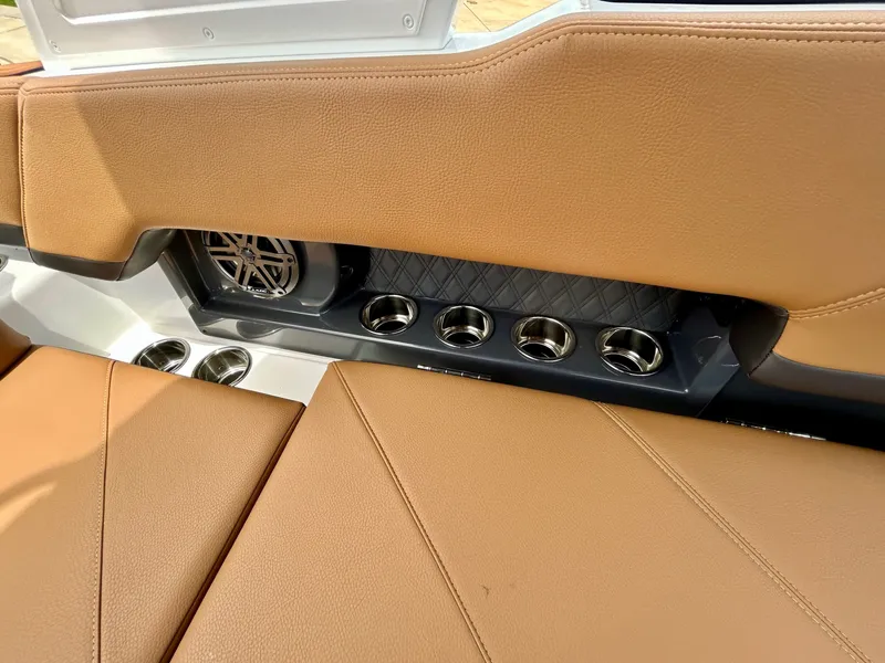 Slide: The Image of The image shows the brown leather seating of a Cobalt R4 boat with cup holders and speaker. - 50
