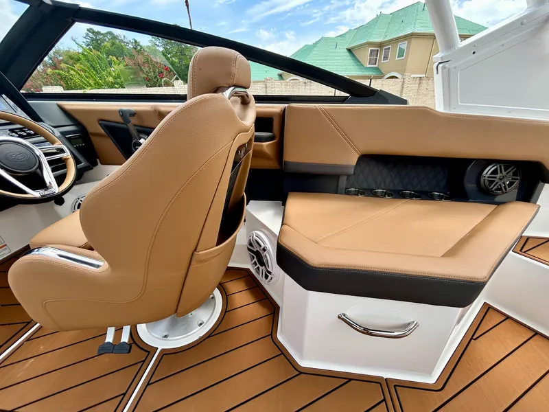 Slide: The Image of The image shows the interior of a 2027 Cobalt R4 boat with brown leather seats and wood flooring. - 44