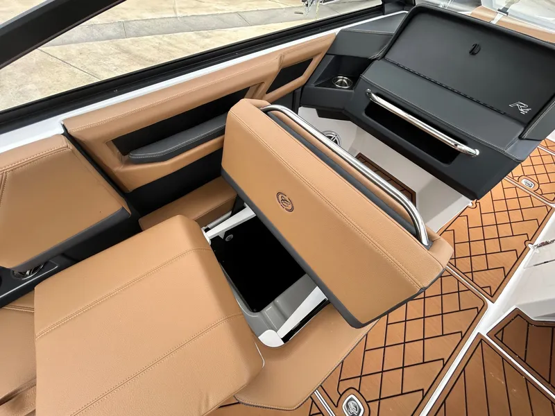 Slide: The Image of The image shows the interior of a 2027 Cobalt R4 boat with brown seats and storage space. - 38