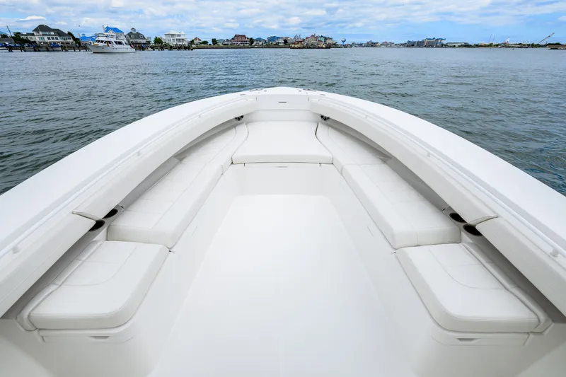 Slide: The Image of 2022 Regulator 34 Center Console boat with spacious seating, docked near waterfront homes. - 28