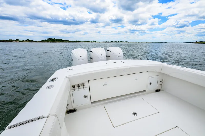 Slide: The Image of 2022 Regulator 34 Center Console boat on open water, featuring triple engines. - 22