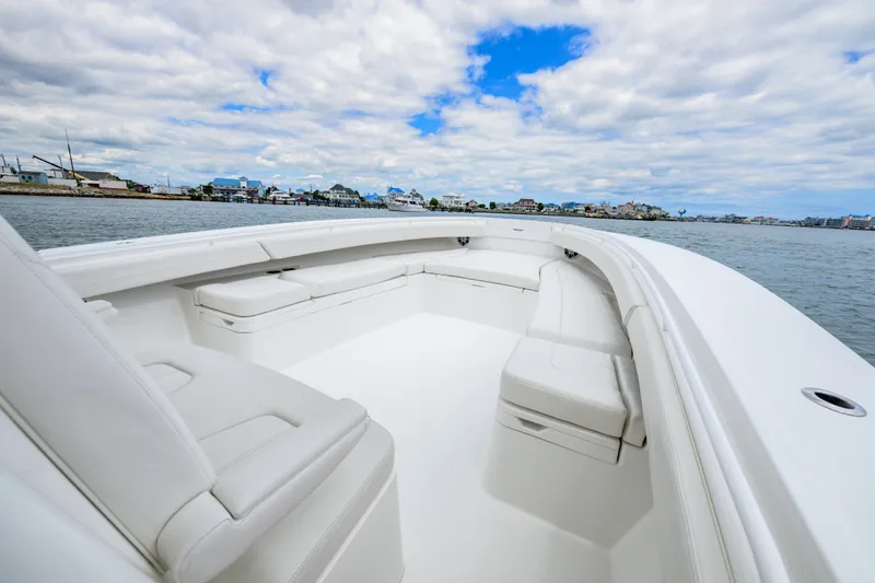 Slide: The Image of 2022 Regulator 34 Center Console boat with spacious seating, docked near coastal town. - 27