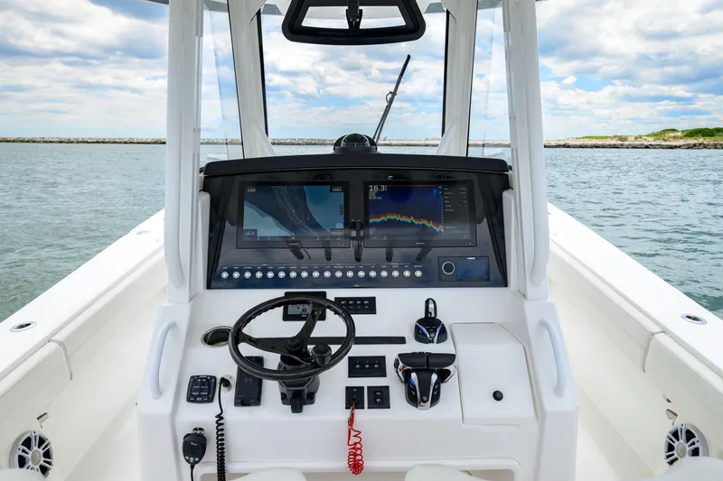 Slide: The Image of 2022 Regulator 34 Center Console boat dashboard with advanced navigation system on open water. - 13