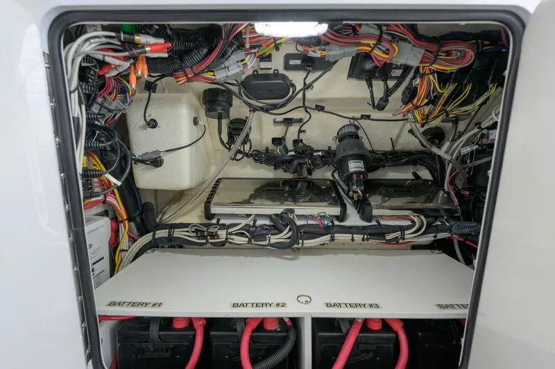 Slide: The Image of 2022 Regulator 34 Center Console electrical compartment with wiring and battery setup. - 34