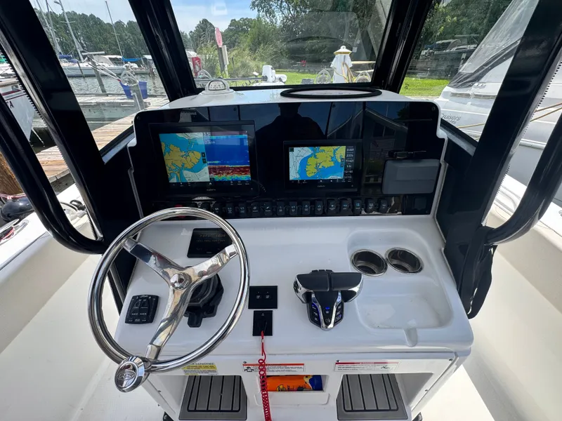 Slide: The Image of The cockpit of a 2024 Sea Hunt Gamefish 25 with modern navigation systems and controls. - 13