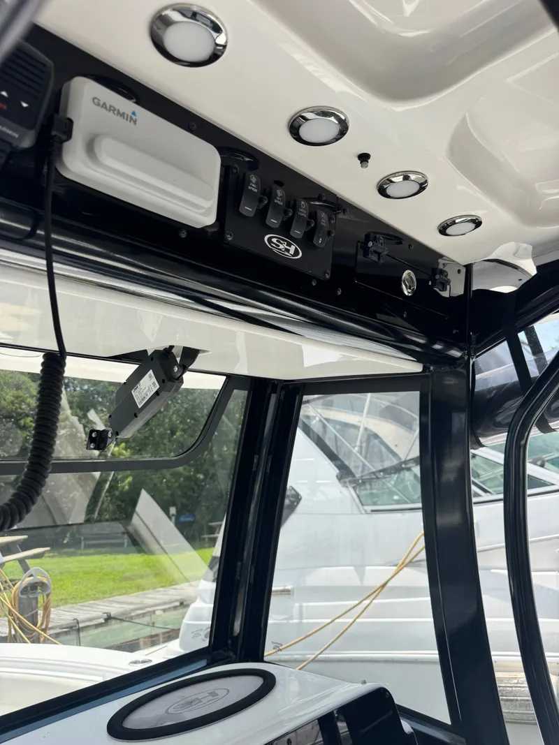 Slide: The Image of The image shows the cockpit of a 2024 Sea Hunt Gamefish 25 boat with modern electronics. - 15