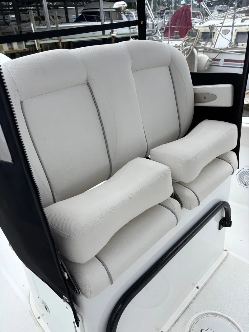 Slide: The Image of The 2024 Sea Hunt Gamefish 25 features cushioned white seats with armrests. - 10