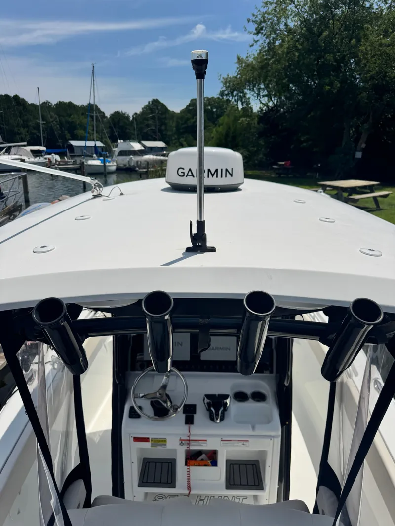 Slide: The Image of The image shows the cockpit of a 2024 Sea Hunt Gamefish 25 boat with fishing rod holders. - 16