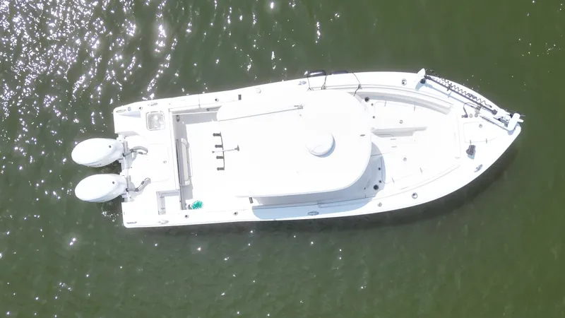 Slide: The Image of Aerial view of a white Sea Hunt Gamefish 25 boat on green water, featuring twin outboard motors. - 4