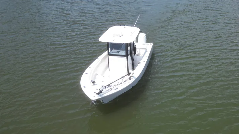 Slide: The Image of A white boat floating on calm water, featuring a covered helm and an open front area. - 2