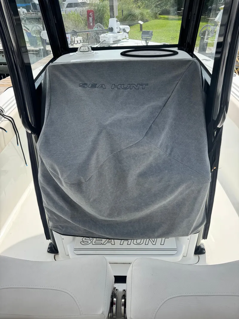 Slide: The Image of The image shows the cockpit of a 2024 Sea Hunt Gamefish 25 boat with a cover. - 11