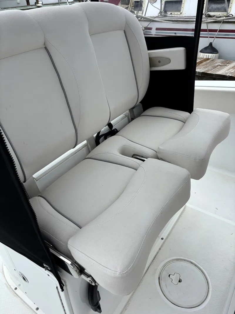Slide: The Image of The 2024 Sea Hunt Gamefish 25 features cushioned double seats with armrests and a white interior. - 9