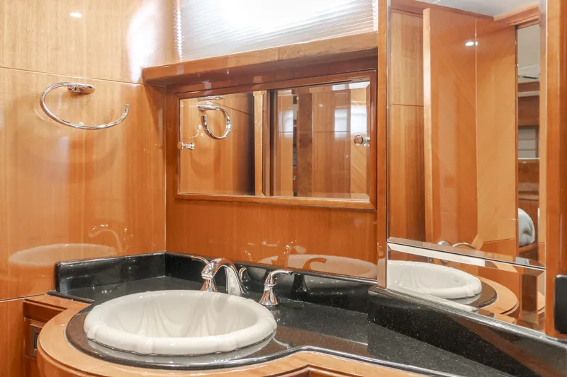 Slide: The Image of The image shows a luxurious bathroom with a sink and large mirror, surrounded by wood paneling. - 44