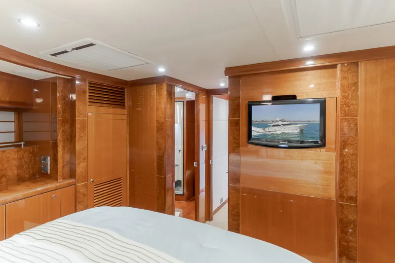 Slide: The Image of Luxurious bedroom with wood paneling, a flat-screen TV, and an adjoining bathroom. - 48