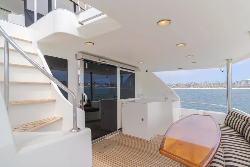 Slide: The Image of The 2010 Ocean Alexander 68 Motor Yacht features an elegant aft deck with wood details and seating area. - 21