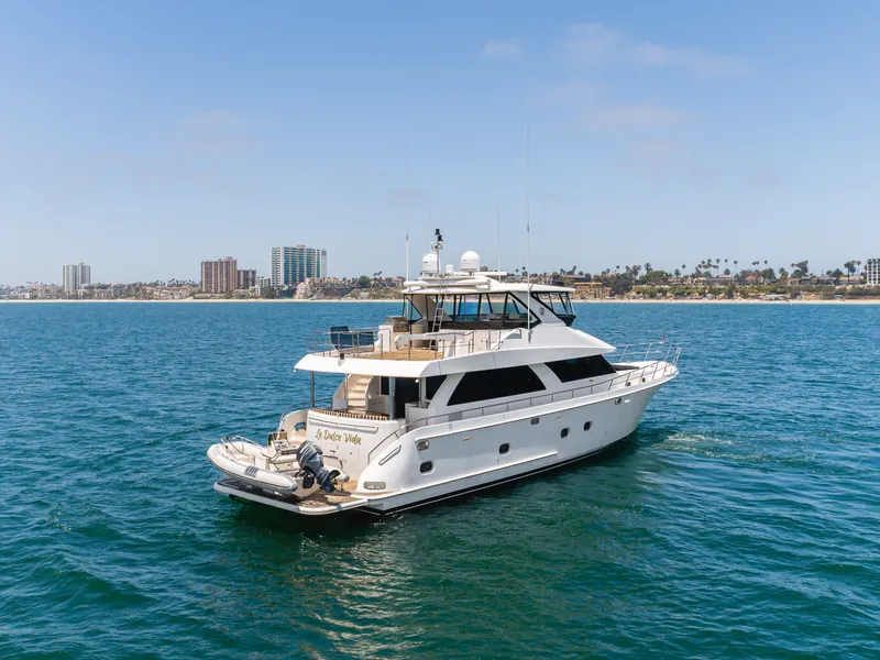 Slide: The Image of A luxurious white yacht cruises on calm waters, with a city and palm trees in the background. - 4