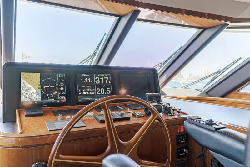 Slide: The Image of The cockpit of a 2010 Ocean Alexander 68 Motor Yacht with a wooden steering wheel and navigation screens. - 34