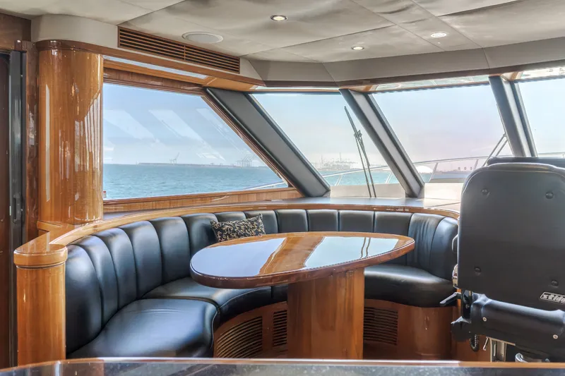Slide: The Image of Interior of a luxury yacht featuring a sleek wooden table and cushioned seating by large windows. - 32