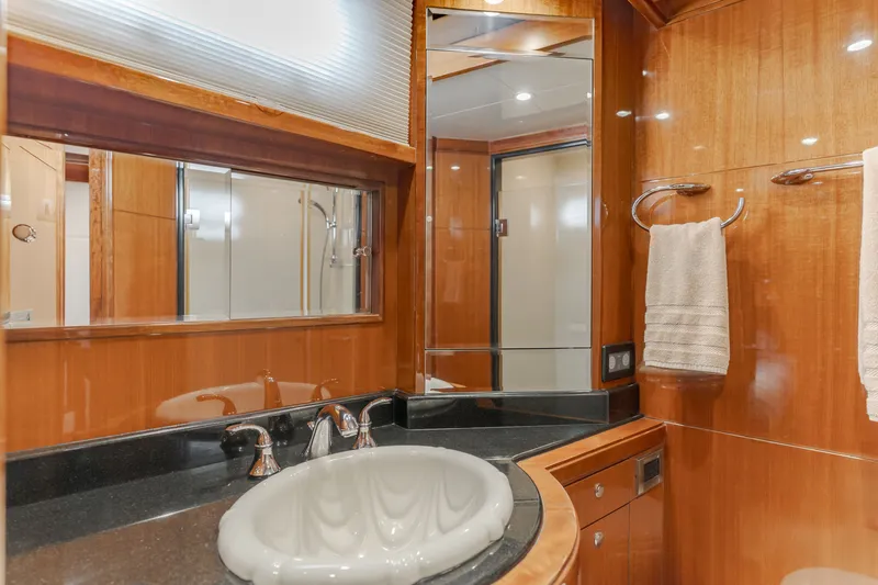 Slide: The Image of The image shows an elegant yacht bathroom with wood paneling, a sink, and a mirror. - 49