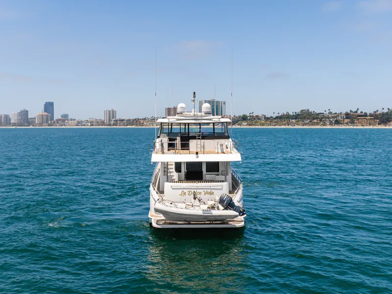 Slide: The Image of A 2010 Ocean Alexander 68 Motor Yacht on calm water with a city skyline in the background. - 3