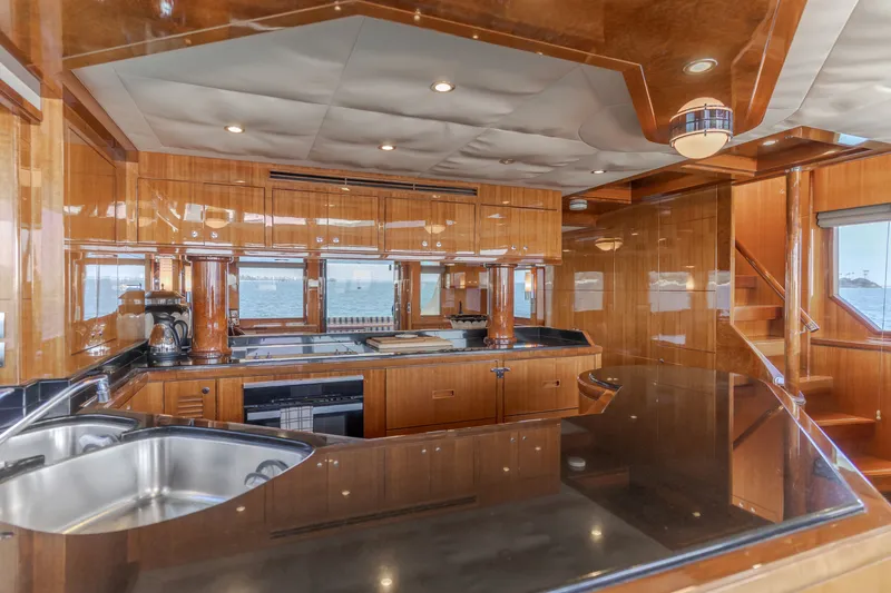 Slide: The Image of The 2010 Ocean Alexander 68 Motor Yacht features a luxurious kitchen with glossy wood finishes and modern appliances. - 28
