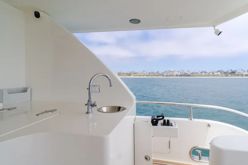 Slide: The Image of The 2010 Ocean Alexander 68 Motor Yacht features an elegant outdoor kitchenette with a sink and ocean view. - 22