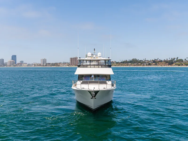 Slide: The Image of A 2010 Ocean Alexander 68 Motor Yacht cruising on calm waters with a city skyline in the background. - 9