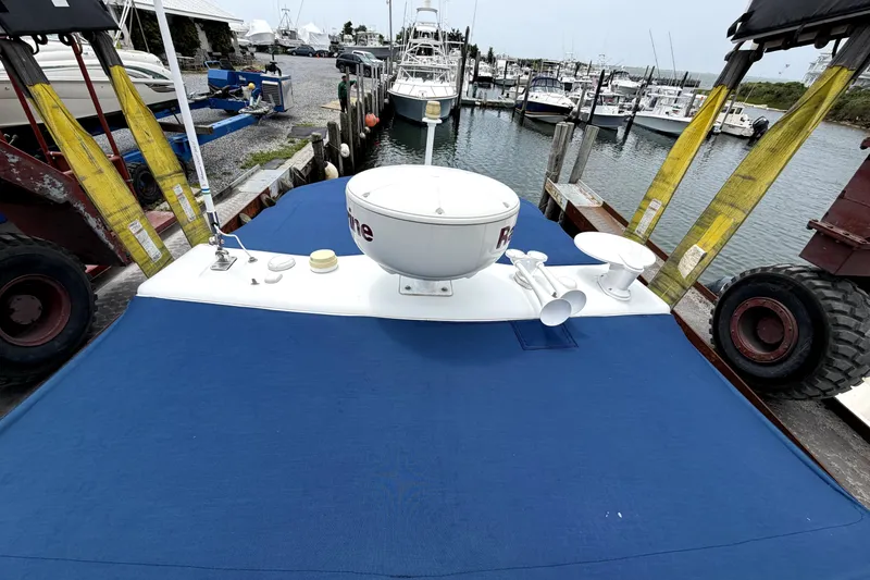 Slide: The Image of 2008 Formula 350 Sun Sport boat docked, featuring blue cover and marine equipment. - 19