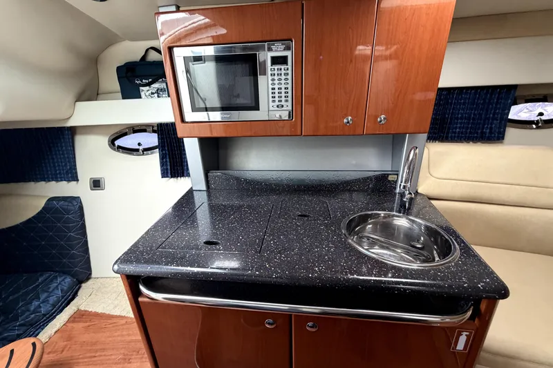 Slide: The Image of 2008 Formula 350 Sun Sport cabin kitchen with microwave, sink, and wooden cabinetry. - 17