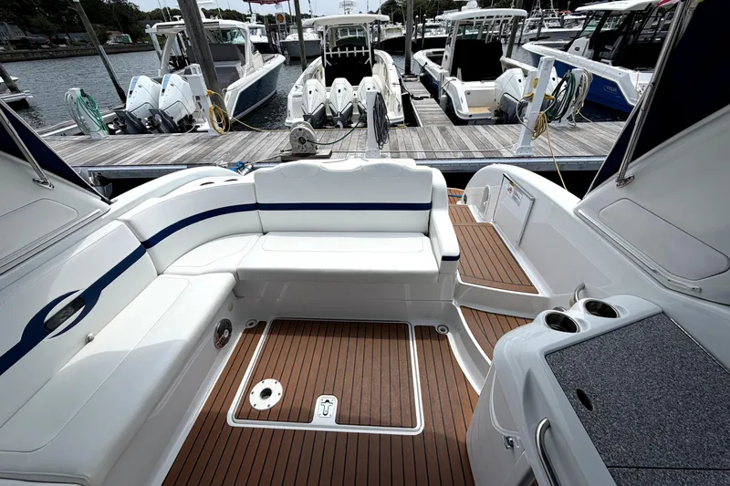 Slide: The Image of 2008 Formula 350 Sun Sport boat interior with white seating and wooden deck at marina. - 11