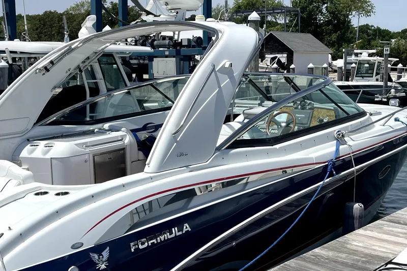 Slide: The Image of 2008 Formula 350 Sun Sport boat docked at marina, sleek design, blue and white exterior. - 2