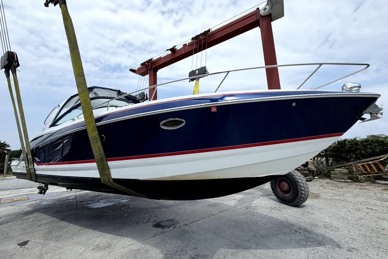 Slide: The Image of 2008 Formula 350 Sun Sport boat suspended on a lift, showcasing sleek design and blue hull. - 13