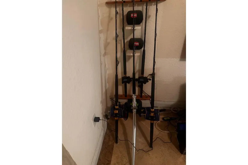 Slide: The Image of Fishing rods with reels on a wooden rack, featuring Penn branding. - 34
