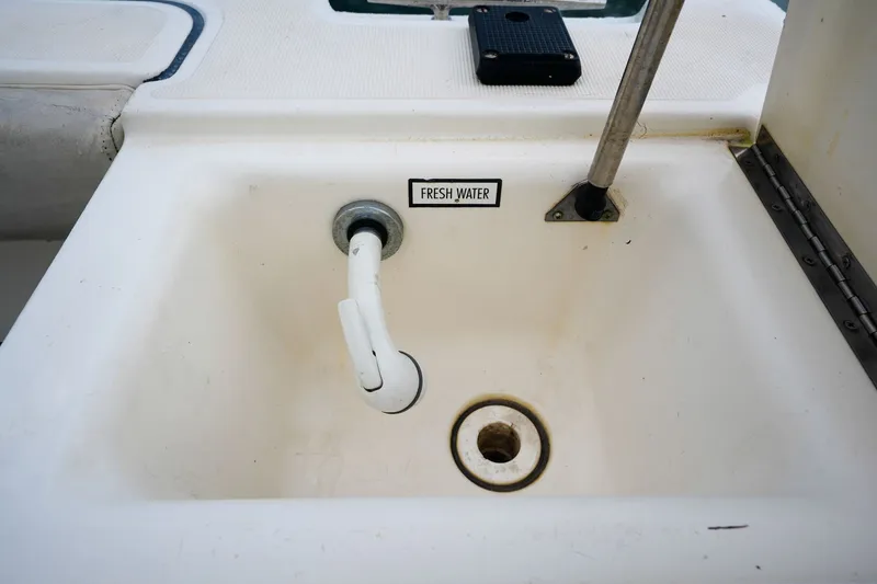 Slide: The Image of Freshwater sink on 2004 Pursuit 3070 Center Console boat, featuring a faucet and drain. - 29