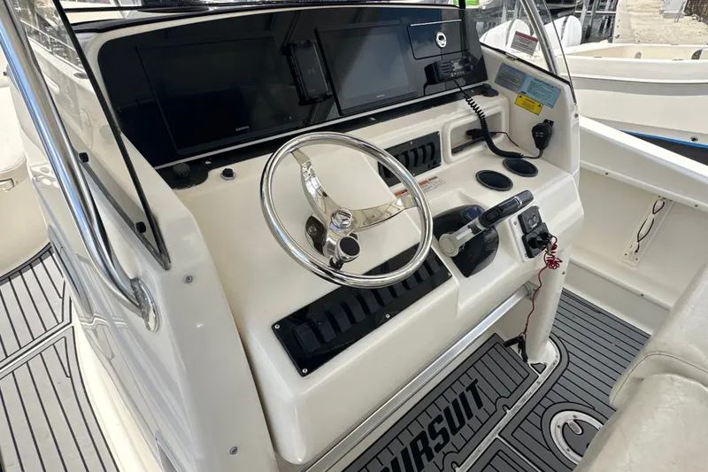 Slide: The Image of 2004 Pursuit 3070 Center Console boat dashboard with steering wheel and navigation equipment. - 8