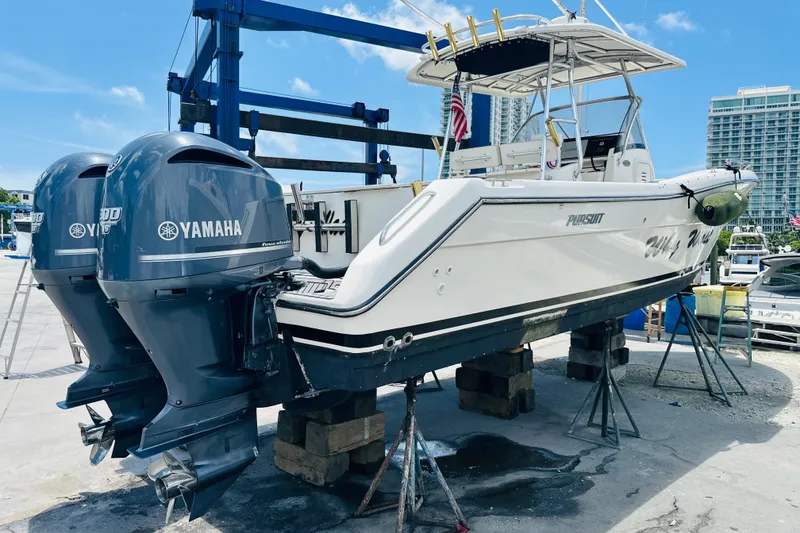 Slide: The Image of 2004 Pursuit 3070 Center Console boat with twin Yamaha engines on a lift. - 2