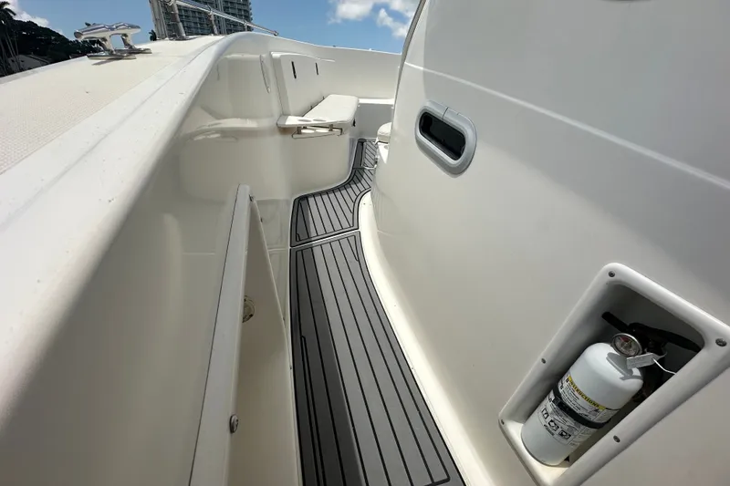 Slide: The Image of 2004 Pursuit 3070 Center Console boat deck with fire extinguisher and seating. - 18