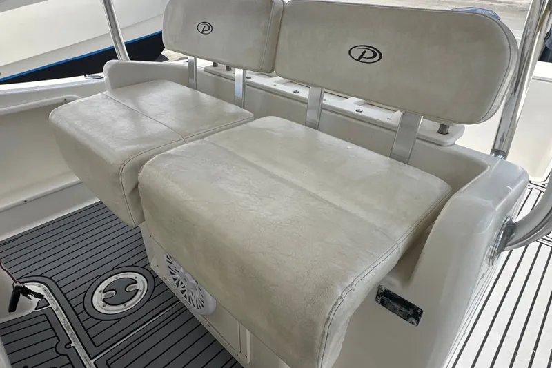Slide: The Image of 2004 Pursuit 3070 Center Console boat seating with white cushioned seats and logo. - 9