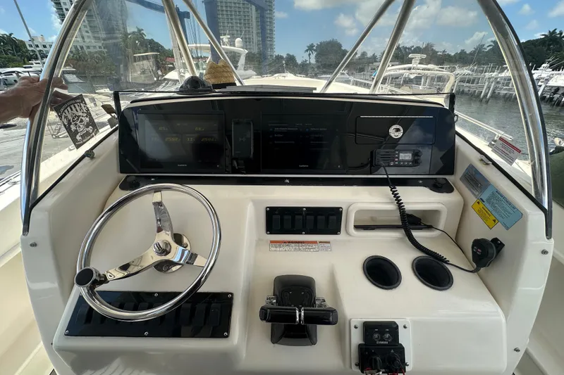 Slide: The Image of 2004 Pursuit 3070 Center Console boat dashboard with steering wheel and navigation controls. - 11