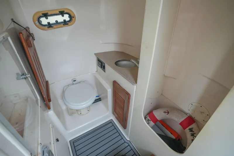 Slide: The Image of Interior of 2004 Pursuit 3070 Center Console boat with toilet, sink, and life preserver. - 31
