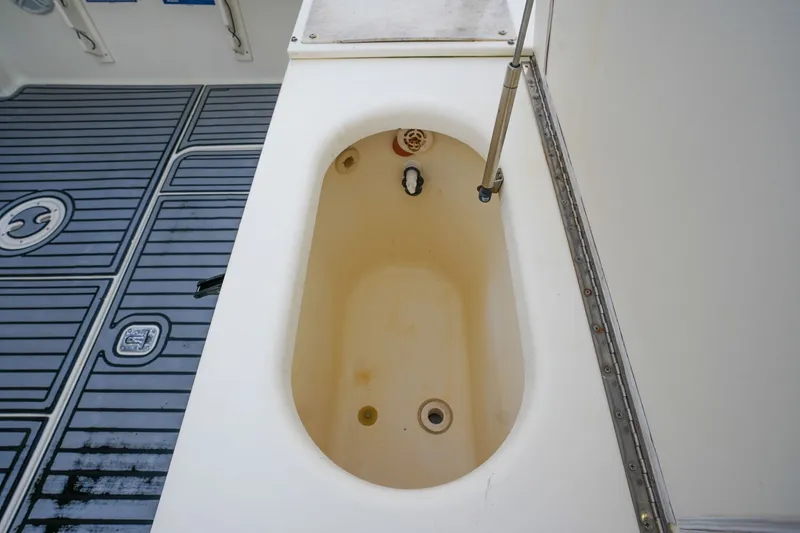Slide: The Image of 2004 Pursuit 3070 Center Console boat interior with storage compartment and non-slip flooring. - 28