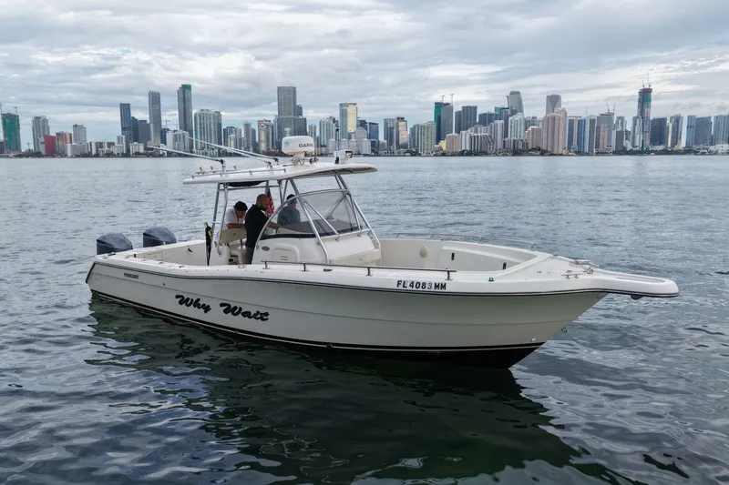 The Image of 2004 Pursuit 3070 Center Console boat on water with city skyline in background. - 0