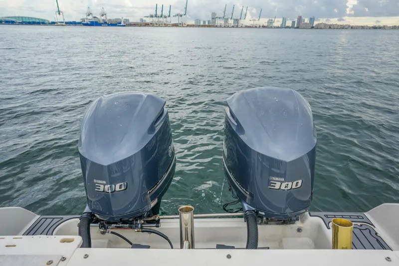 Slide: The Image of Twin Yamaha 300 engines on a 2004 Pursuit 3070 Center Console boat, docked in a harbor. - 30