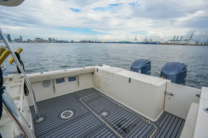 Slide: The Image of 2004 Pursuit 3070 Center Console boat with dual engines, docked near an industrial waterfront. - 26