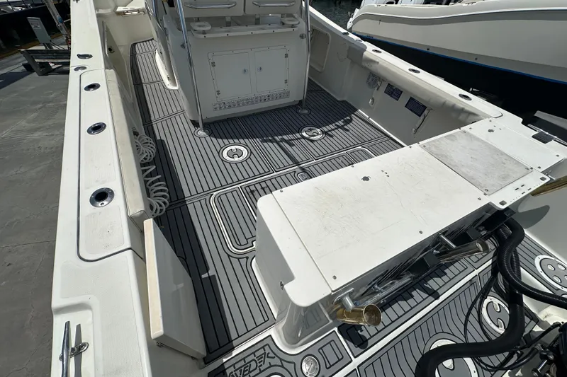 Slide: The Image of 2004 Pursuit 3070 Center Console boat interior with clean deck and fishing rod holders. - 4