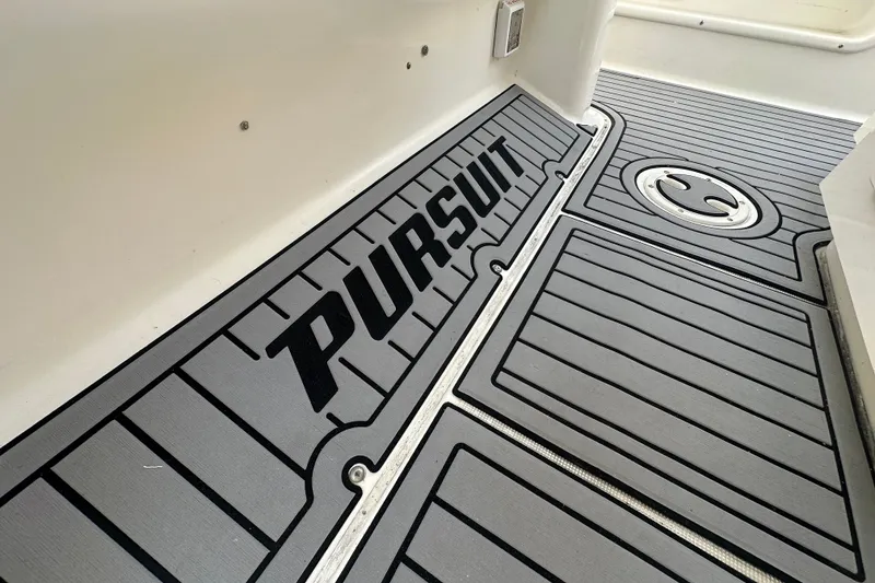 Slide: The Image of 2004 Pursuit 3070 Center Console boat deck with logo and textured flooring. - 10