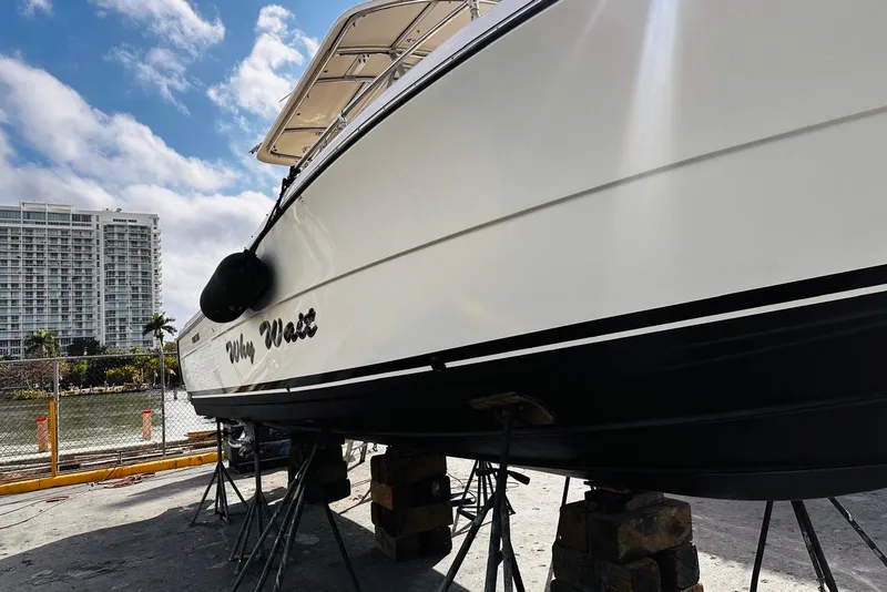 Slide: The Image of 2004 Pursuit 3070 Center Console boat on stands, with cityscape background. - 3