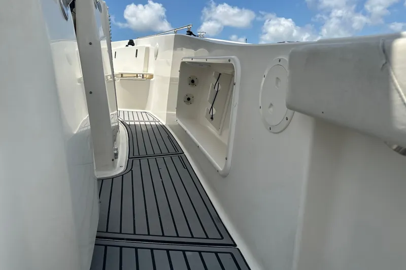Slide: The Image of 2004 Pursuit 3070 Center Console boat deck with storage compartments under a blue sky. - 14