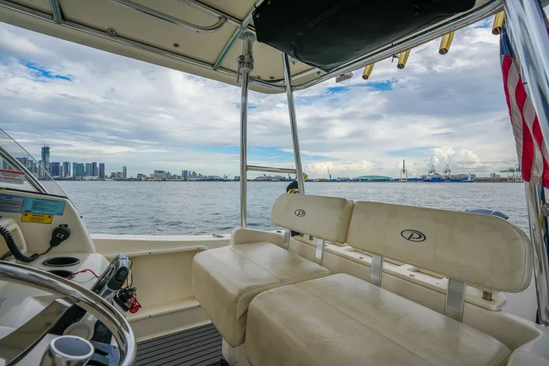 Slide: The Image of 2004 Pursuit 3070 Center Console boat interior with city skyline and ocean view. - 23